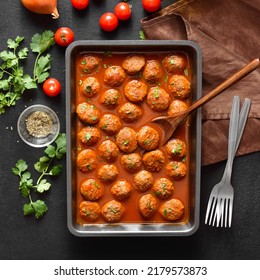 Meatballs With Tomato Sauce In Baking Dish Over Dark Stone Background. Top View, Flat Lay