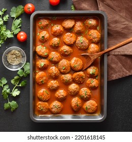 Meatballs With Tomato Sauce In Baking Dish Over Dark Stone Background. Top View, Flat Lay