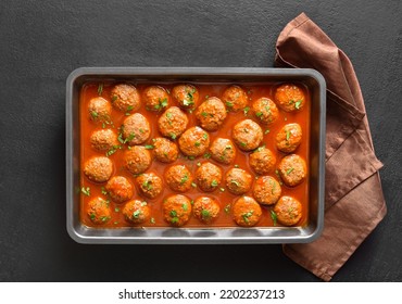 Meatballs With Tomato Sauce In Baking Dish Over Black Stone Background. Top View, Flat Lay