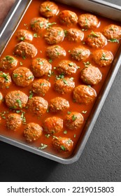 Meatballs With Tomato Sauce In Baking Dish Over Dark Stone Background. Close Up View