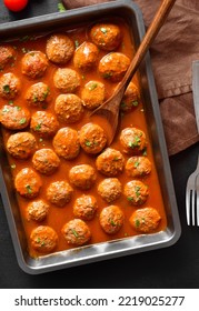 Meatballs With Tomato Sauce In Baking Dish Over Black Stone Background. Top View, Flat Lay