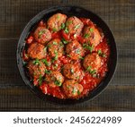 Meatballs with tomato sauce in frying pan, top view