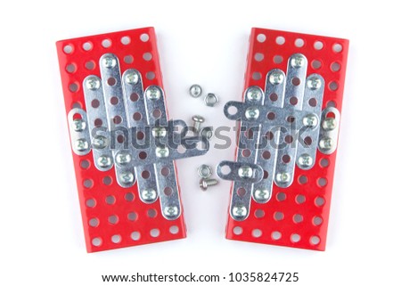 meccano heart: the shared heart of two halves constructed with a constructor, a few screws and nuts between the two halves, on white background, top view, short focus on the Central part