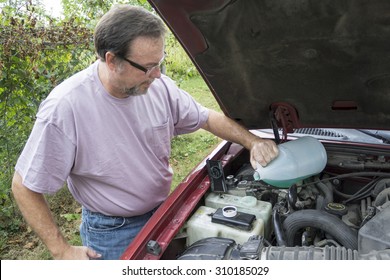 Mechanic Adding Windshield Wiper Fluid To Customers Vehicle