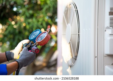 Mechanic Air Conditioner Technician Using Manifold Gauge Checking Refrigerant For Filling Home Air Conditioning And Air Duct Cleaning And Maintenance Outdoor Compressor Unit.