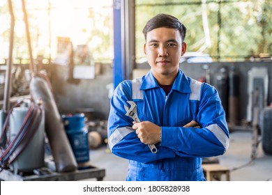 Mechanic Asian Man Fixing Repairing Car Engine Automobile Vehicle Parts Examining Screwing Using Tools Wrench Equipment Working Hard In Workshop Garage Support And Service In Overall Work Uniform