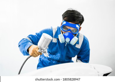 Mechanic Asian man spray painting airbrush pulverizer car body in paint chamber repairing car automobile vehicle parts using tools equipment in workshop garage support service in overall work uniform - Powered by Shutterstock