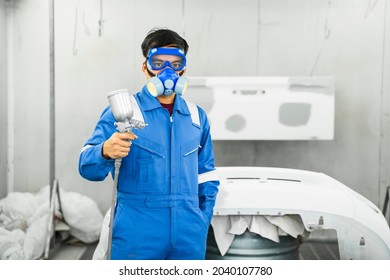 Mechanic Asian man spray painting airbrush pulverizer car body in paint chamber repairing car automobile vehicle parts using tools equipment in workshop garage support service in overall work uniform - Powered by Shutterstock