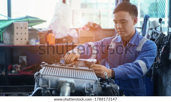 Mechanic\
auto mechanic in uniform repairing.car in auto machine tools ready\
to be used with car service.selective\
focus.