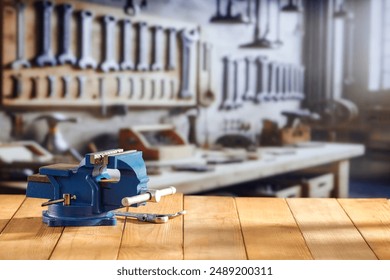 Mechanic bench vice on a wooden workbench in a craftsman's workshop. A blurred wall with tools in the background. Empty advertising space  for mounting products and objects. - Powered by Shutterstock