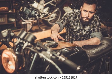 Mechanic Building Vintage Style Cafe-racer Motorcycle  In Custom Garage