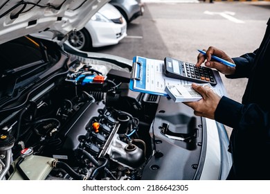 Mechanic Calculates The Cost Of Car Repairs To Customer At Garage Workshop, Car Auto Services And Maintenance Check Concept.