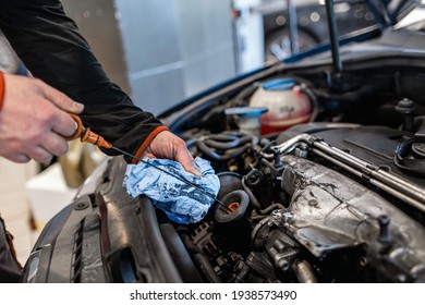 Mechanic In A Car Repair Shop Checking The Oil In A Vehicle