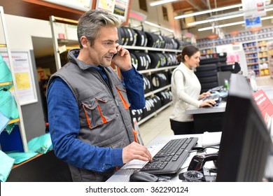 Mechanic In Car Repair Shop Talking On Phone