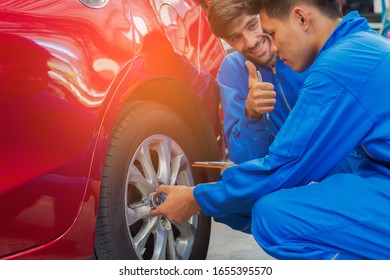 Mechanic In The Car Service Department Is Checking The Condition Of The Wheels And The Engine. Professional Service Concept