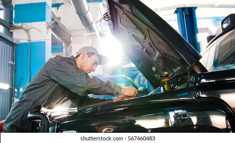 Mechanic In Car Service - Repairing In Engine Compartment For Luxury SUV, Wide Angle