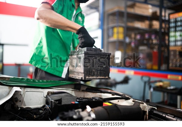 mechanic\
changing car battery An engineer is replacing a car battery because\
the car battery is dead. concept car\
care