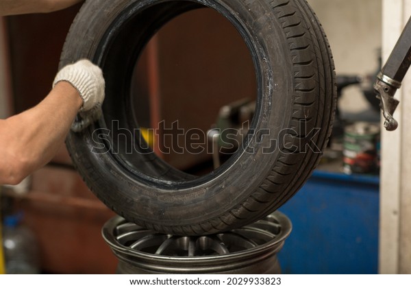 Mechanic\
changing car tire fitting. Wheel tyre\
repairing
