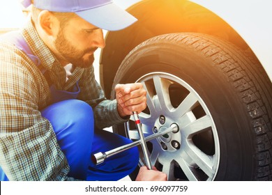 Mechanic Changing Car Tire With Wheel Wrench