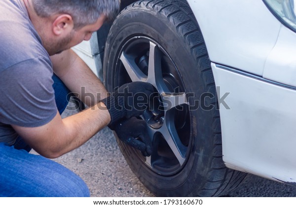 mechanic changing car wheel,\
car mechanic changing the wheel of a car, car mechanic fixing a\
wehicle