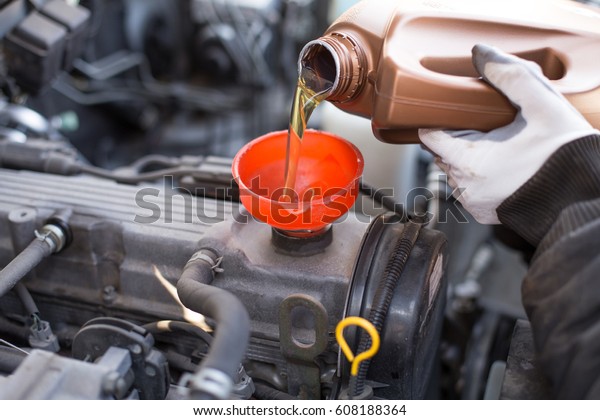 mechanic changing oil in a\
car