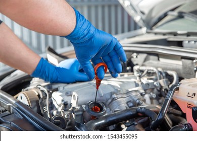 Mechanic changing oil to a car engine