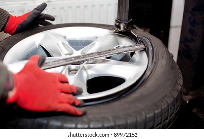 Mechanic Changing Tire In Car Service. Tire Rotation Machine