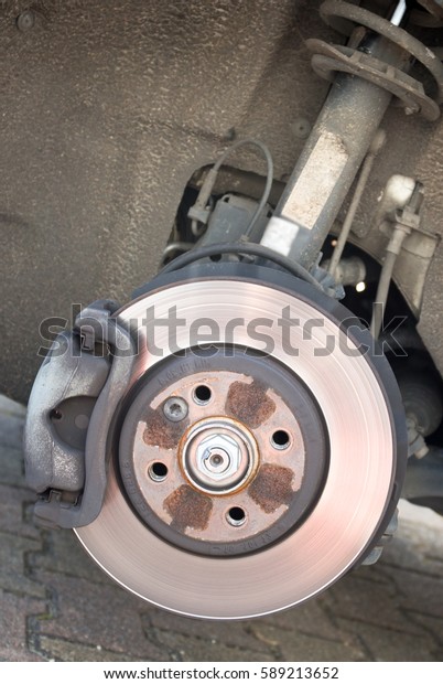 A\
mechanic is changing a wheel and brakes of a modern\
car