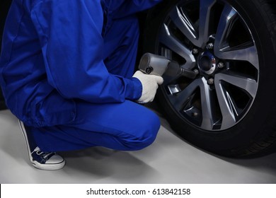 Mechanic changing wheel, closeup