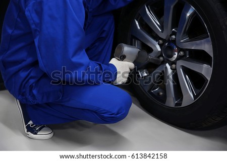 Mechanic changing wheel, closeup