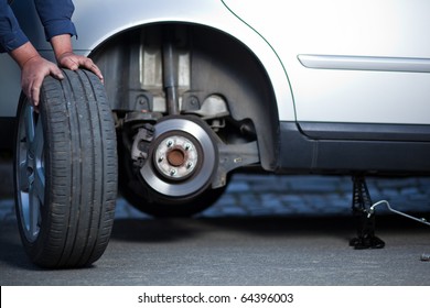 Mechanic Changing A Wheel Of A Modern Car (shallow DOF; Color Toned Image)