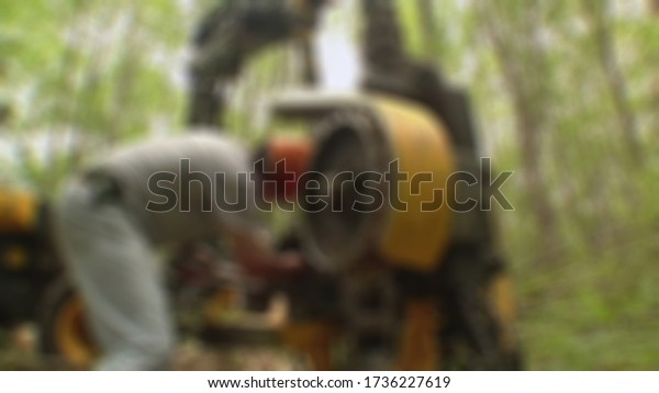 Mechanic changing wheel on car with impact\
wrench.blurry\
background.