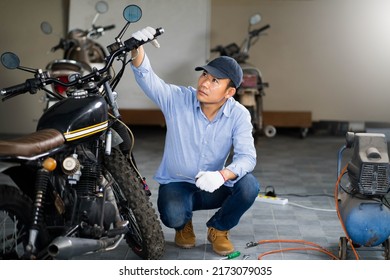 Mechanic check brake system on motorcycle brake reservoir in garage. - Powered by Shutterstock