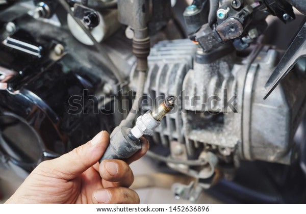 Mechanic Check Spark Plug Inspection and Maintenance,\
Inspection Prior to Installation in engine ignition and electrical\
systems at motorcycle garage.repair and maintenance motorcycle\
concept.        