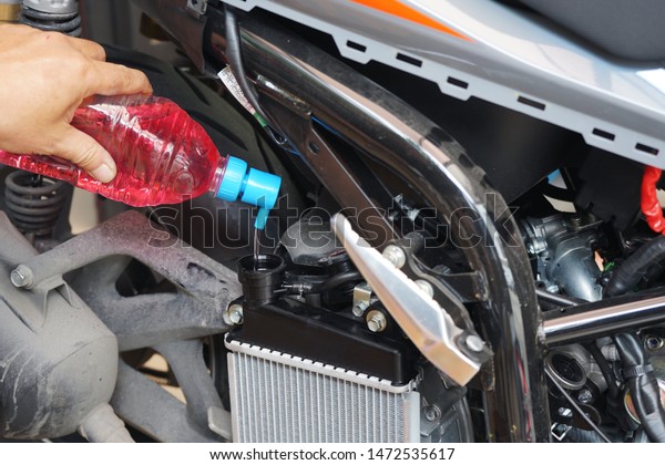 Mechanic Check water and\
Add water to motorcycle or scooter radiator in the garage, radiator\
is the main component of the cooling system and to keep the engine\
from overheating