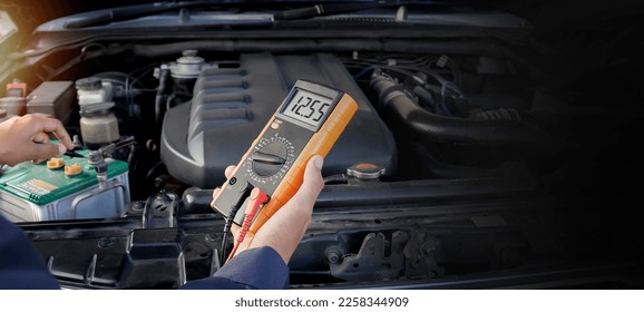 Mechanic checking car battery voltage - Shutterstock ID 2258344909
