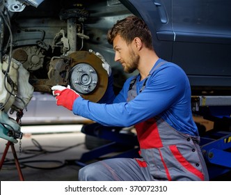 Mechanic Checking Car Brake System In A Workshop