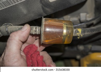 Mechanic Checking A Fuel Filter On A Tractor.