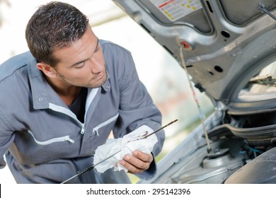Mechanic checking the oil level of a car
