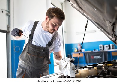 Mechanic Checking Oil Level In The Car