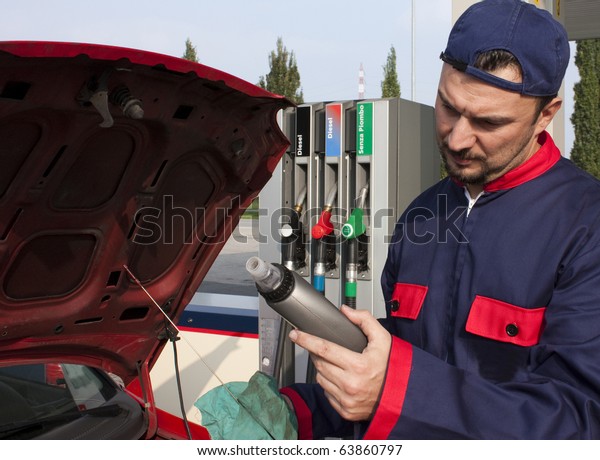 Mechanic Checking Oil\
Level at Gas Station