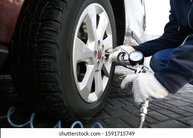 Mechanic Checking Tire Air Pressure At Car Service, Closeup