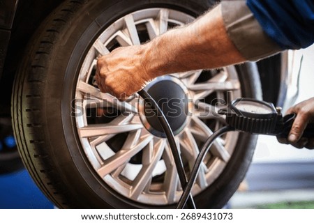 Mechanic checking tire pressure using a gauge for vehicle safety and maintenance