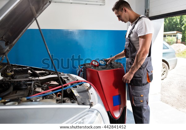 Mechanic\
checks the air conditioner at service\
station