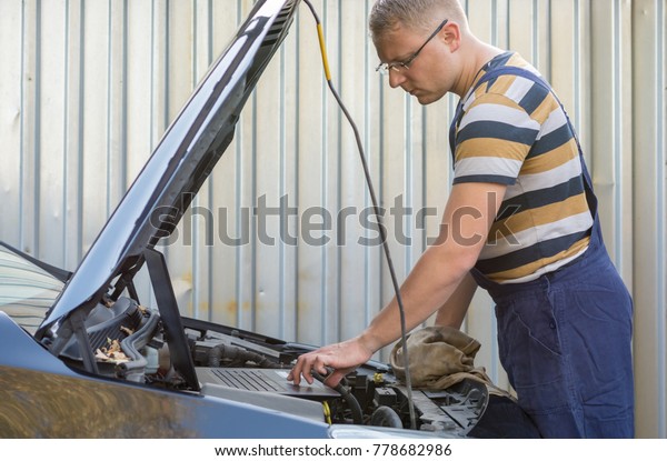 Mechanic checks electronics\
of a car