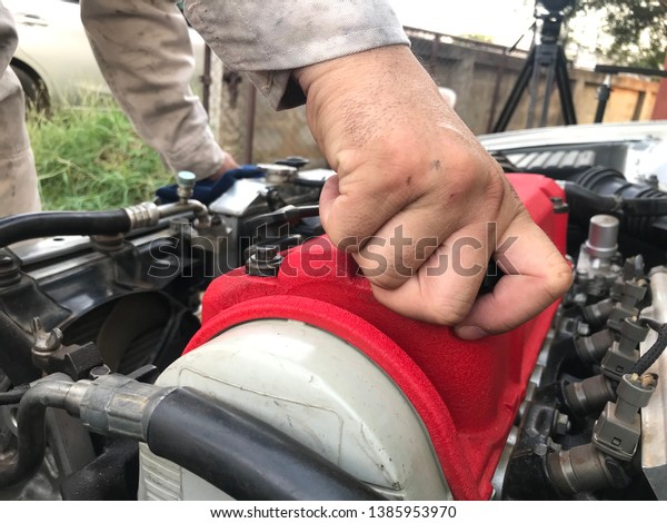 The mechanic checks the\
engine oil.