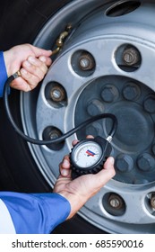 A Mechanic Checks The Tire Pressure Gauge Truck