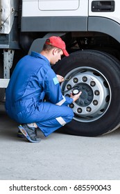 A Mechanic Checks The Tire Pressure Gauge Truck