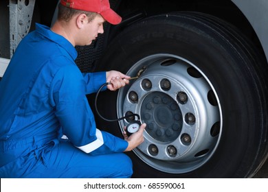 A Mechanic Checks The Tire Pressure Gauge Truck