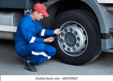 A Mechanic Checks The Tire Pressure Gauge Truck